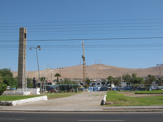 Chacabuco-Allee ("avenida
                      Chacabuco") mit dem Karlspark ("parque
                      Carlos") bzw. Feldpark ("parque Ba�ez
                      del Campo") mit einem Denkmal, und im
                      Hintergrund ein Kran und die W�ste