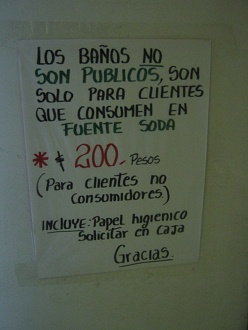 La puerta del ba�o con la indicaci�n como
                          usar el ba�o, con el precio de 200 pesos
                          chilenos para no consumidores del restaurante