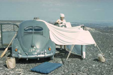 Maria Reiche in den 1950er Jahren mit einem
                        Volkswagen (VW K�fer) und einem Besen, um die
                        Linien zu putzen