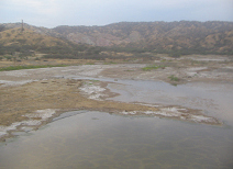 Panamericana in Nord-Peru bei Mancora,
                        Fluss�berquerung mit W�stenbergen im
                        Hintergrund