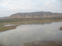 Panamericana in Nord-Peru zwischen Mancora
                        und Tumbes, Fluss�berquerung mit W�stenbergkette
                        im Hintergrund
